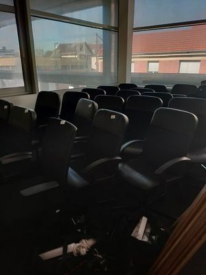 a room with a lot of chairs and a large window