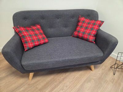 un canapé gris orné de coussins rouges et verts