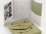 an open book sitting on top of a table next to a green purse