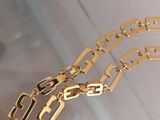 a close up of a gold chain bracelet on a table