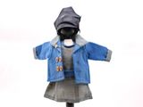 une poupée qui porte une veste et une robe bleues
