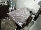 a kitchen with a sink and a table with a plastic cover on it