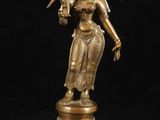 une statue en bronze représentant une femme tenant un oiseau sur son bras