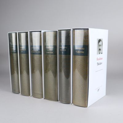 six books in a row on a white surface with a box