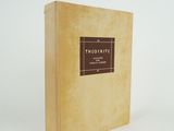 un vieux livre à la couverture marron posé sur une table blanche
