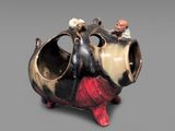 a small figurine of a cow with a man sitting on top of it