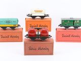 four toy trains sitting on top of boxes with names on them