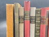several old books are lined up in a row on a table