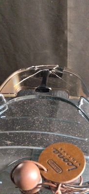 une assiette en verre sur laquelle est posé un biscuit et un bol en verre contenant un biscuit