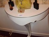 une table blanche sur laquelle se trouvent un miroir et un vase