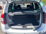 the back of a white car with its trunk open in a parking lot