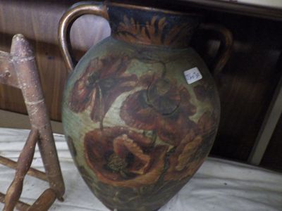 a large vase sitting on a table next to a chair