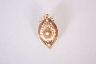 une photo d'une broche en or posée sur un fond blanc