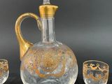 three glasses and a decanter sitting on a table