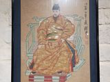 painting of a man sitting on a chair in a room with a brick wall in the background