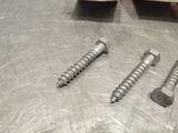 two screws that are sitting on a metal table