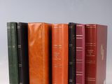 six different colored books lined up in a row on a white surface