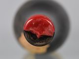 a close up view of a wine bottle with a red cap