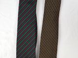 two ties are laying on a white surface, one is green and the other is brown
