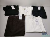 Quatre paires de pantalons pour homme et un t-shirt sont disposés sur une table