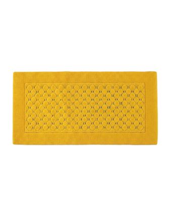un tapis de bain jaune orné d'un motif floral