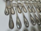 a lot of silver spoons and forks on the table