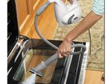 a person using a steam cleaner to clean an oven