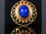 a close up of a pair of gold and lapis stone earrings