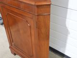 a wooden cabinet with a glass door on top of it