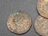 three ancient coins sitting on top of a table next to each other