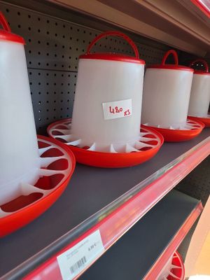 many plastic buckets on the shelves of a store