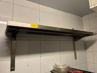 a metal shelf with a sign on it in a kitchen