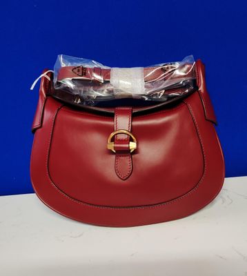 un sac à main rouge sur lequel est posé un sac en plastique