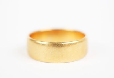 a close up of a gold wedding ring on a white background