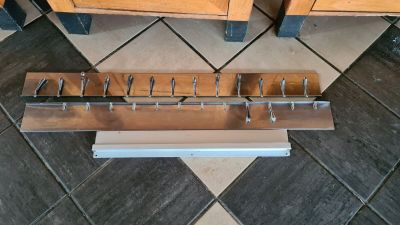 a picture of a wooden rack with a bunch of nails