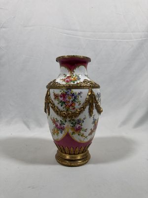 a white vase with a pink and gold decoration on it