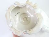 a person holding a white bowl with a flower design on it