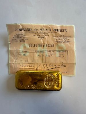 un lingot d'or posé à côté d'un ticket de caisse sur une table