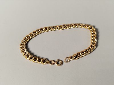 a gold chain bracelet on a white background