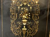 an old black and gold book with a gold design on it
