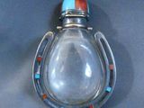 a glass bottle with a horseshoe shaped lid on a table