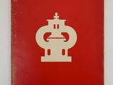 a red book with a white logo on it sitting on top of a table