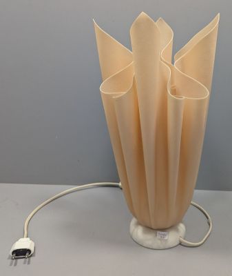 une lampe posée sur une table, à laquelle est rattaché un cordon