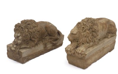 une paire de lions sculptés dans la pierre, posés sur des socles, sur fond blanc
