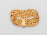 un bracelet en chaîne dorée avec un nœud sur fond blanc