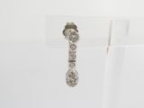 a close up of a pair of earrings on a clear stand