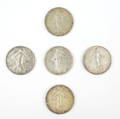 six types différents de pièces d'argent sur une surface blanche