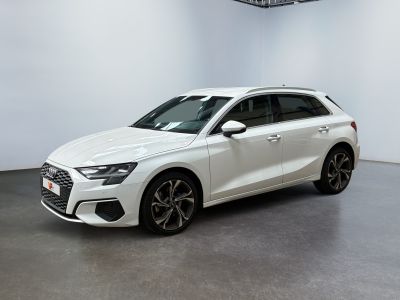 Une voiture blanche est garée dans une pièce blanche au sol noir.
