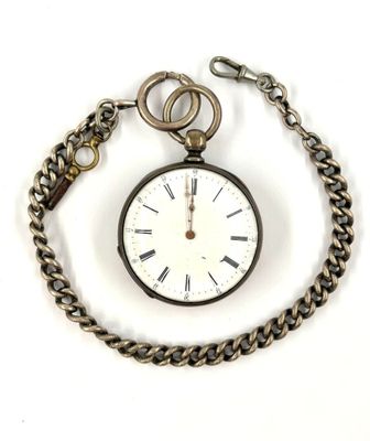 a pocket watch with a chain around it on a white surface