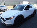 the white mazda cx - hr is parked in front of a building